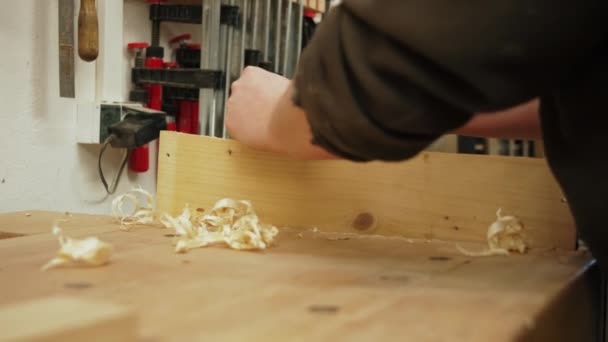 彼の工房で木工の仕事をしている間にジャック飛行機を使って男性大工のクローズアップショット 高品質4K映像 — ストック動画