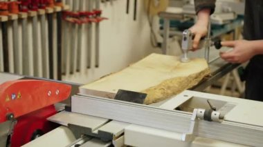 Marangoz ahşap bir tahtayı dairesel bir testereyle kesmek için klemp kullanarak onarıyor. Yüksek kalite 4k görüntü
