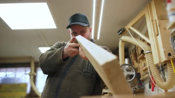 Ξυλουργός Εξετάζει Μια Ξύλινη Σανίδα Μετά Την Ισοπέδωση Χρησιμοποιώντας Μια — Αρχείο Βίντεο