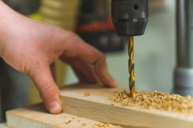 Tahtada delik açmak için dönen elektrikli tornavidanın metal matkabı. Yüksek kalite fotoğraf