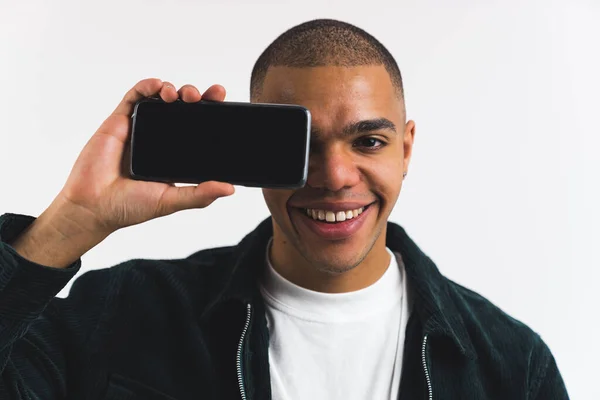 快乐的非洲裔美国男孩 横向地拿着电话靠近他的脸 空屏幕 中等的特写 高质量的照片 — 图库照片