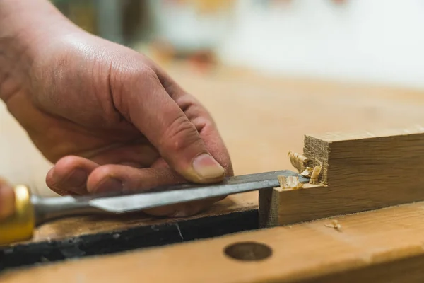 木製の板を閉じて滑らかにするためにノミで木彫りの大工の手 高品質の写真 — ストック写真
