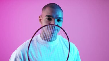 Beyaz tişörtlü Afro-Amerikalı bir adam kameranın yanında tenis raketi tutuyor. Yüksek kalite 4k görüntü