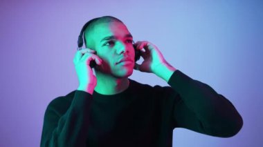 Afro-Amerikalı erkek model, kulaklık kullanarak yatıştırıcı müzik dinliyor. Yüksek kalite 4K görüntü