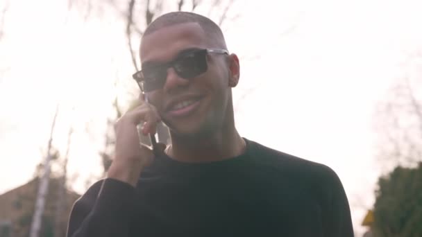 Zwarte Man Met Een Zonnebril Glimlacht Terwijl Hij Praat Met — Stockvideo