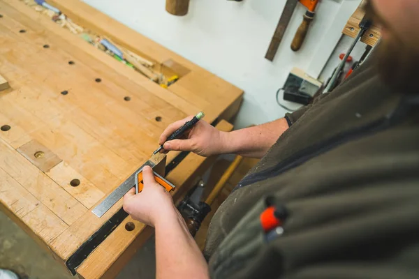 木製の板にマーカーや定規を使用して慎重に線を描く大工の手 高品質の写真 — ストック写真