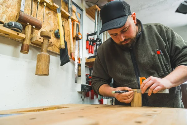 stock image shot of carpenters hands using set square tool wor a wooden plank, making wooden products. High quality photo