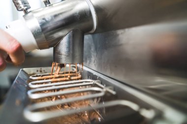 Pastörizatör makinesinden dondurucuya çikolatalı dondurma döküyorum. Yüksek kalite fotoğraf