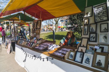 04.18.2023 Hillegom, Hollanda. Yerel Hillegom sanatçıları resimlerini ve diğer sanat eserlerini satıyor. Markette masanın arkasında oturan yetişkin bir kadın. Yüksek kalite fotoğraf