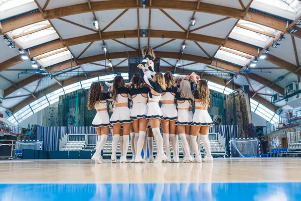 Cheerleaderki Ćwiczą Trzymając Dziewczynę Powietrzu Boisku Koszykówki Wysokiej Jakości Zdjęcie — Zdjęcie stockowe