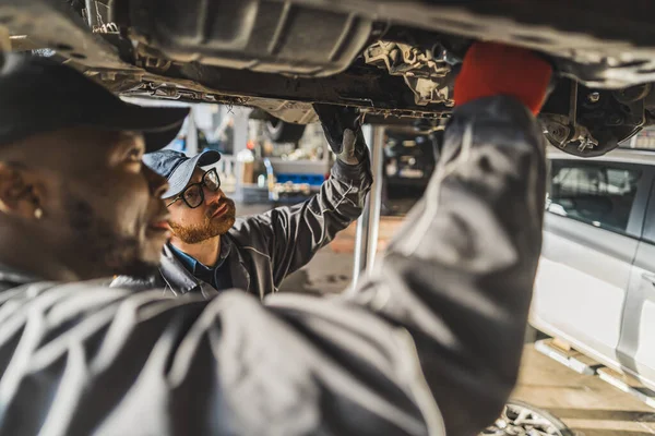 Två Bilservicearbetare Reparerar Bilen Med Hydraulisk Lyft Högkvalitativt Foto — Stockfoto
