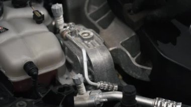 Siyah eldivenli bir elin motor parçalarını küçük siyah bir süngerle silişi yakın çekim videosu. Yüksek kalite 4k görüntü