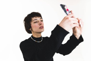 Siyah kazaklı, kısa saçlı bir kadının selfie çekerken yakın çekimi. Model konsepti. Yüksek kalite fotoğraf