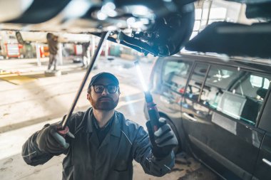 Otomobil tamircisi garajda araba durumunu kontrol ediyor. Yüksek kalite fotoğraf