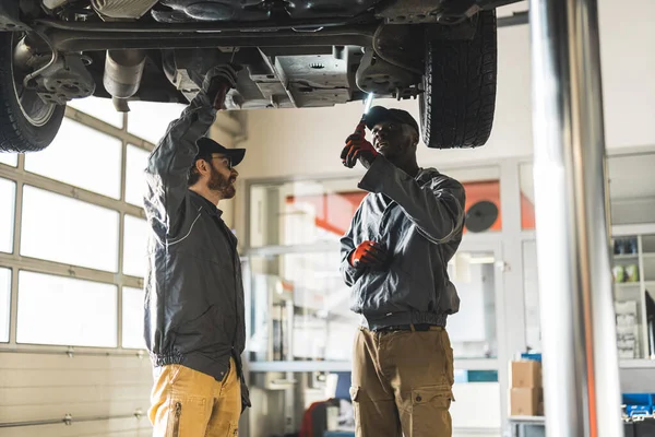 Shot Lifted Car Two Men Specialists Inspecting Car Suspension High — Stock Photo, Image