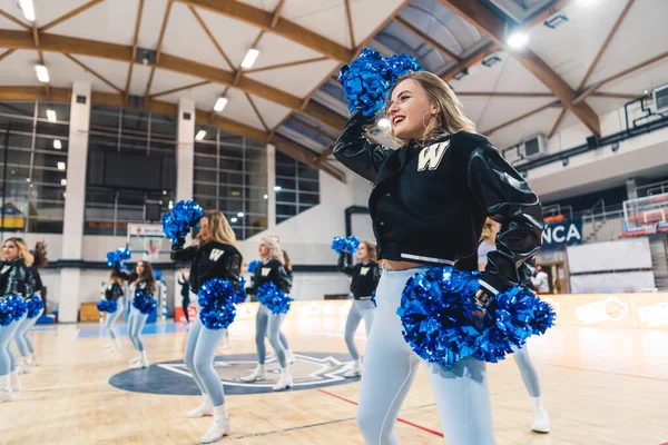 Universitárias Cheerleaders Uniformes Dançando Com Pompons Azuis Uma Quadra Basquete — Fotografia de Stock