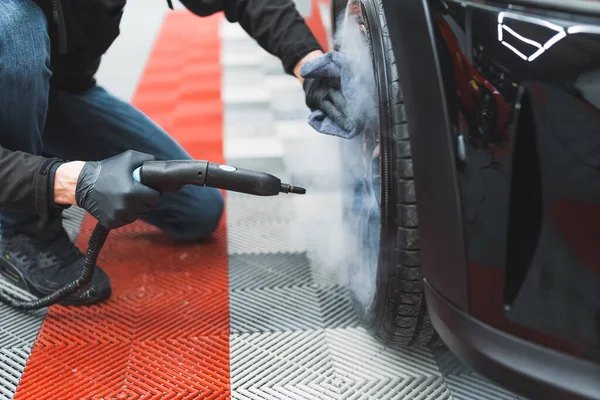 자동차를 자세하게 다루는 바퀴와 타이어를 청소하는 사용되는 뜨거운 기구의 각도를 — 스톡 사진