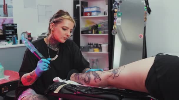 Fokuserad Kvinnlig Tatueringsmästare Gör Tatuering Sina Klienters Ben Tatueringssalongen Högkvalitativ — Stockvideo