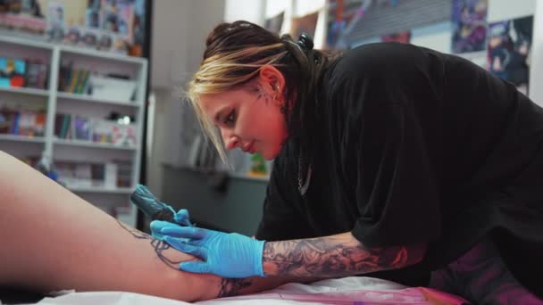Εστιασμένη Γυναίκα Δάσκαλος Τατουάζ Κάνει Ένα Τατουάζ Στο Πόδι Των — Αρχείο Βίντεο