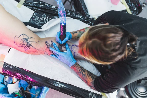 女性の足に黒と白の入れ墨を作るタトゥーアーティストのトップダウンショット 高品質の写真 — ストック写真