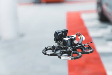 Bulanık arka planı olan siyah birinci şahıs görüntü dronuna odaklan. Teknoloji önsöze geçiyor. Drone uçuyor ve filme çekiyor. Yüksek kalite fotoğraf