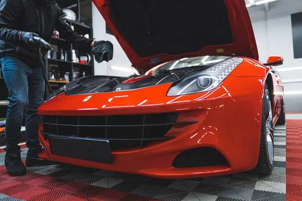 2023ポーランドのワルシャワ 赤いフェラーリのエンジンエリアをきれいにするために熱い蒸気機械を使用する準備ができて得る詳細な専門家の車の低角度屋内ショット 高品質の写真 — ストック写真