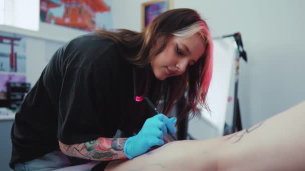 Female Tattoo Master Doing Tattoo Clients Leg Using Handheld Tattoo — Stock Video