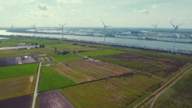 Green polders in the Netherlands. Row of windmills stretching along the riverside. High quality 4k footage