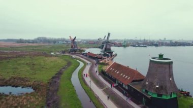 Drone flying over Zaanse Schans windmills museum and the river Zaan, Netherlands. High quality 4k footage