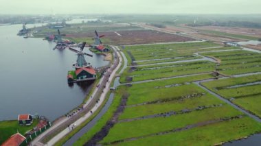 Windmills of the Zaans Museum in Netherlads, surrounded by green fields and water. High quality 4k footage