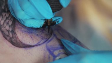 Closeup tattoo making process - Client getting a tattoo in a tattooing parlour. High quality 4k footage