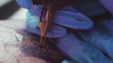Tattoo master drawing tattoo on client body using tattoo machine with black ink . High quality 4k footage