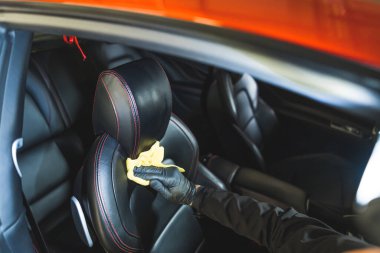 Araba temizleme konsepti, tamircide ön koltuğu bezle temizlemek. Yüksek kalite fotoğraf