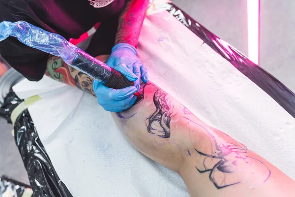 高角度的纹身过程 腿纹身的概念 重点艺术家使用专业设备 黑色墨水纹身 高质量的照片 — 图库照片
