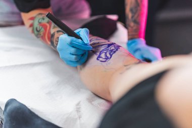 Sanatçı, beyaz müşterisinin derisine dövme tasarımı çiziyor. Freehand tekniği müşterilerin bakış açısından çekildi. Yüksek kalite fotoğraf