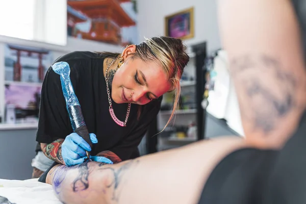 Mutlu Profesyonel Kadın Dövme Sanatçısı Stüdyoda Sevdiği Bayan Müşterisinin Bacağına — Stok fotoğraf