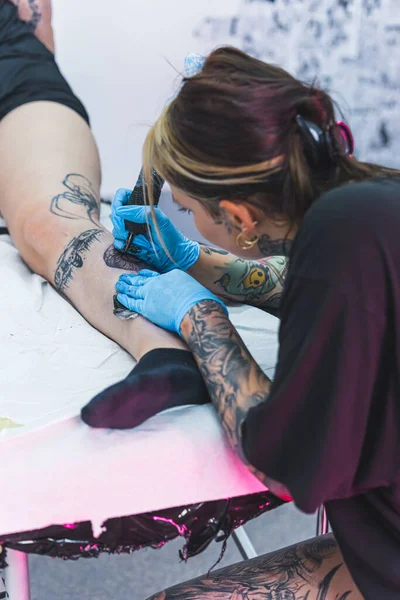Вертикальный Внутренний Снимок Процесса Татуировки Опытная Женщина Татуировщица Рисует Татуировку — стоковое фото