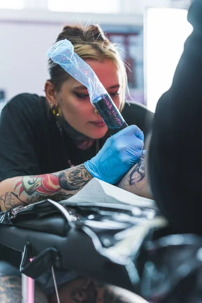 重点女性纹身艺术家画纹身在她的客户 腿纹身的概念 真正的人创造艺术 垂直室内拍摄 高质量的照片 — 图库照片