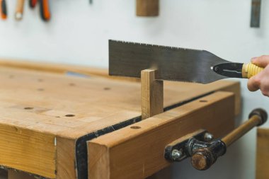 Testereyle odun kesmek için tezgah mengenesi kullanmak. Yüksek kalite fotoğraf