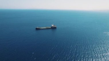 Mavi gölgeler ufku. Kargo gemisi bulutlu mavi gökyüzüne ve dalgalı denize karşı, hava aracı atışı. Yüksek kalite 4k görüntü