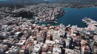Yunanistan 'ın Girit kentinde küçük beyaz binaları olan güzel ve görkemli kıyı kenti Agios Nikolaos' un kuş bakışı manzarası. Yüksek kalite 4k görüntü