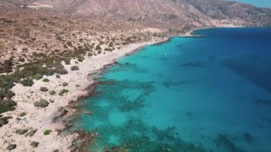 Yunanistan 'ın Girit kentindeki turkuaz deniz sularının kıyısındaki vahşi kayalık Kedrodasos plajı, insansız hava aracı manzarası. Yüksek kalite 4k görüntü