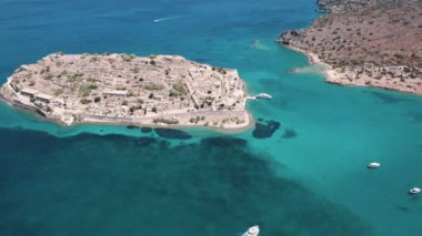 Spinalonga - Yunan kurak kayalık adası. Doğu Girit 'te Elounda yakınlarındaki ünlü küçük ada havadan görüldü. Yaz tatili konsepti. Yüksek kalite 4k görüntü