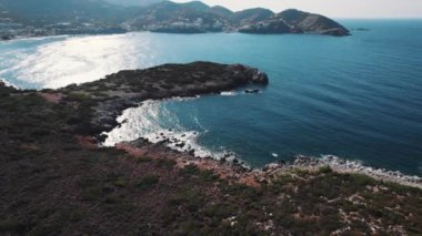 Doğal deniz kıyısı. Güzel Mirabello Körfezi kuş bakışı açıdan görülüyor. Çiğ kayalık plaj. Yunanistan 'da seyahat. Yüksek kalite 4k görüntü