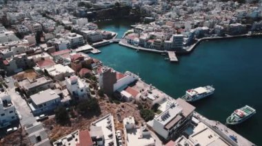 Agios Nikolaos 'un havadan görünüşü - yoğun nüfuslu birçok binalı bir Yunan kenti. Deniz kıyısında bir şehir kavramı. Yüksek kalite 4k görüntü