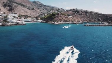 Botlar Yunanistan 'ın Sfakia Limanı' na doğru yarışıyor. Hava görüntüsü. Tekne konseptiyle seyahat etmek. Yunanistan 'ın güzel deniz ve kıyı şeridi. Yüksek kalite 4k görüntü