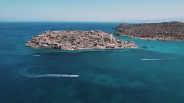 Küçük bir Yunan adası, Spinalonga. Cüzam Adası 'nın hava aracı görüntüsü. Bir adacığı çevreleyen turkuaz deniz suyunu temizleyin. Yüksek kalite 4k görüntü