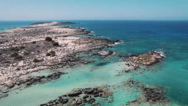 クレタ島の有名なエラフォニシビーチの素晴らしい自然の景色 ロッキー海岸とその浅い鮮やかな青い水の空中視点 高品質の4K映像 — ストック動画