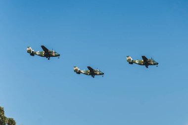 Hava gösterisi konsepti. Mavi gökyüzünde uçan kamuflaj boyasıyla kaplı üç askeri uçak. - Evet. Yüksek kalite fotoğraf