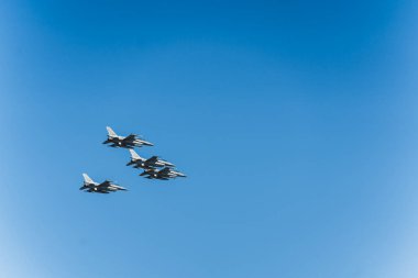Mavi gökyüzünde hava gösterisinde dört savaş uçağı. Açık hava askeri geçit töreni konsepti. Askeri güçlerin gücü. Yüksek kalite fotoğraf